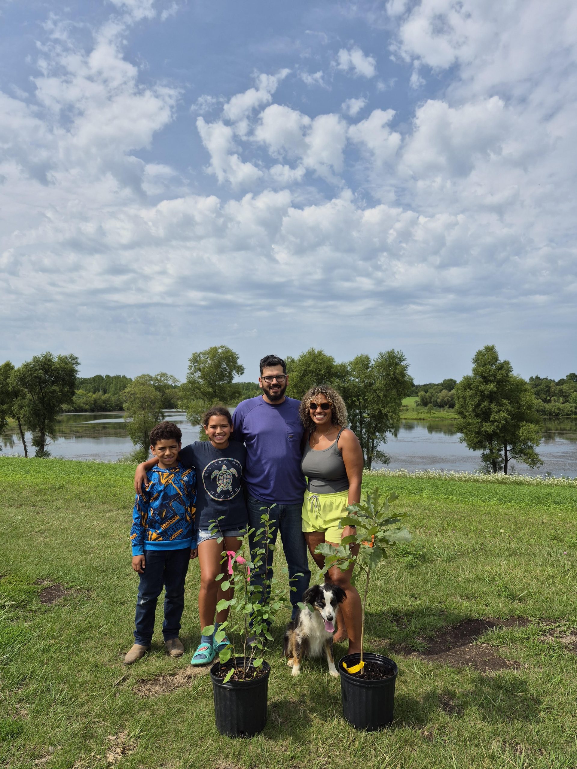 A family of four in a park with an oak tree.