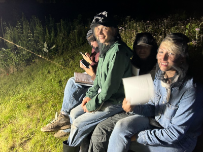Three people outdoors at night